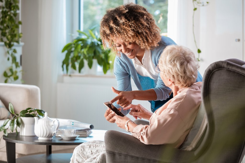 verzorger-vrouw-uitleg-smartphone